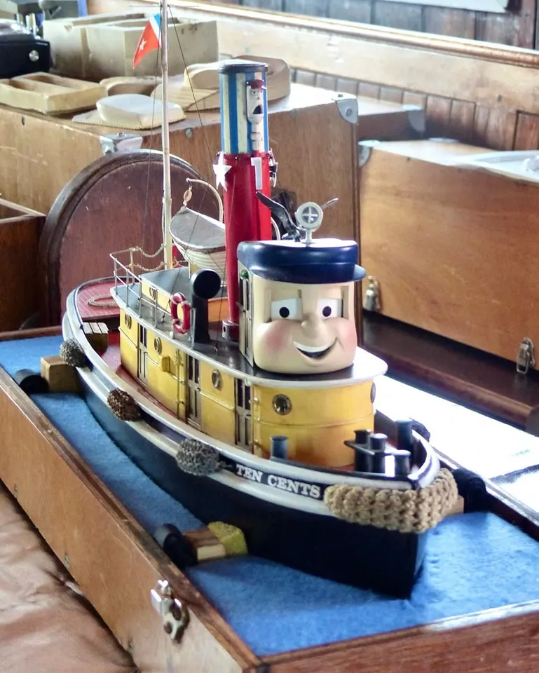Ten Cents TUGS character model displayed in a wooden case