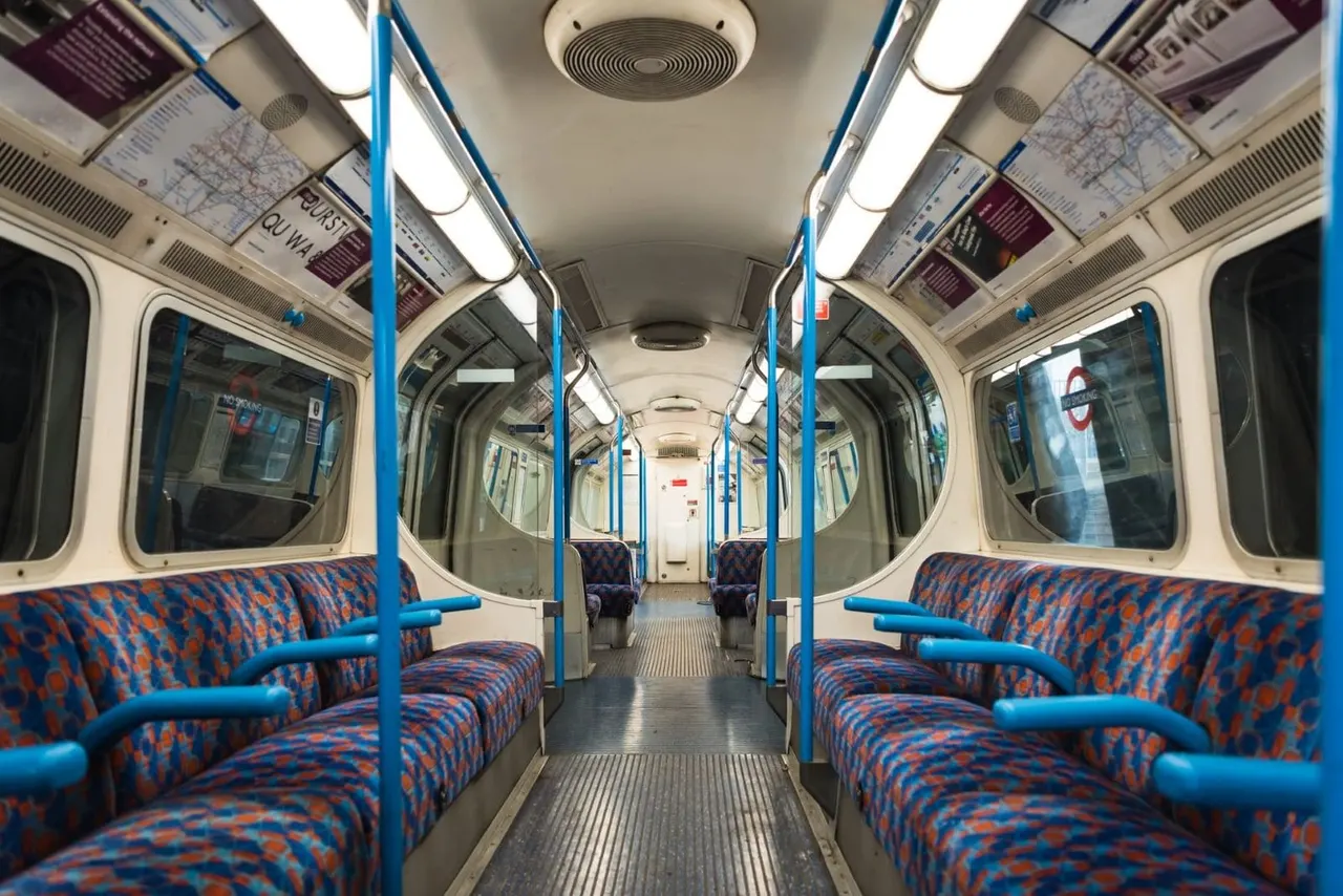 This is a designed graphic (specifically a photograph of a London Underground train carriage interior that has been used as promotional or display content for the venue).

GRAPHIC