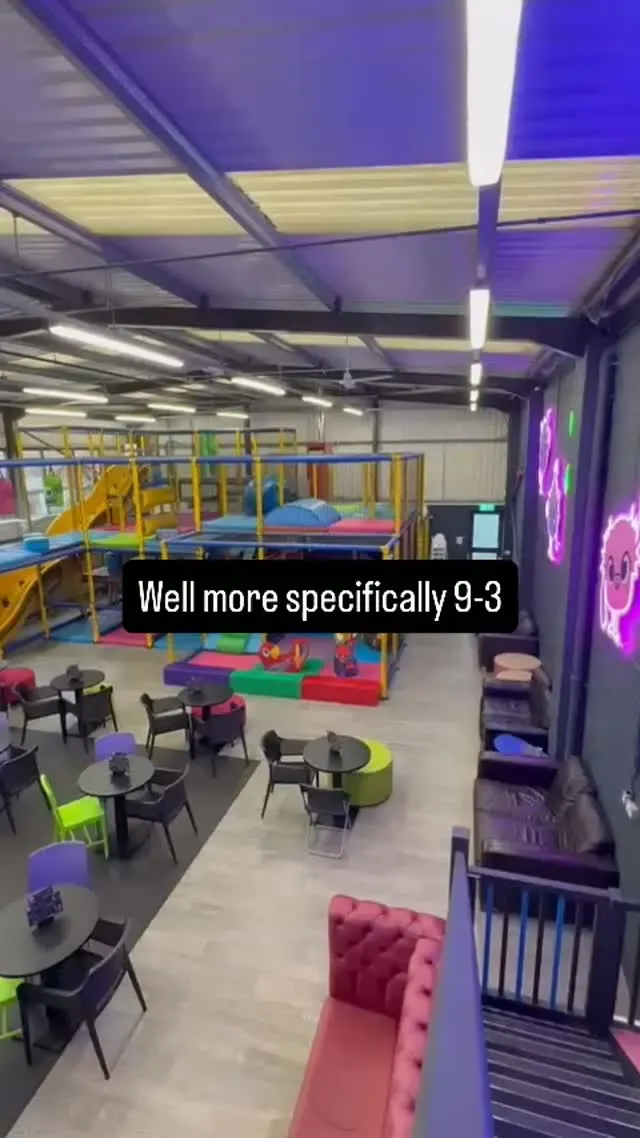 Soft-play frame overview with cafe tables and neon wall signs