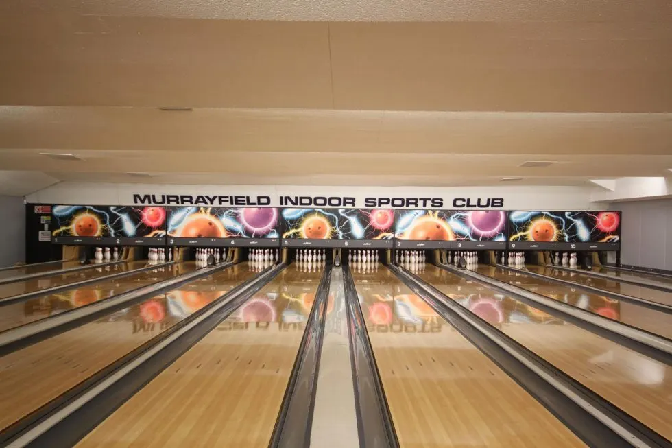 Empty bowling alley with multiple lanes and illuminated pins at Murrayfield Indoor Sports Club.