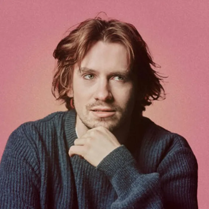 This is a designed graphic (portrait photograph used as a promotional image with a solid coloured background), so:

GRAPHIC