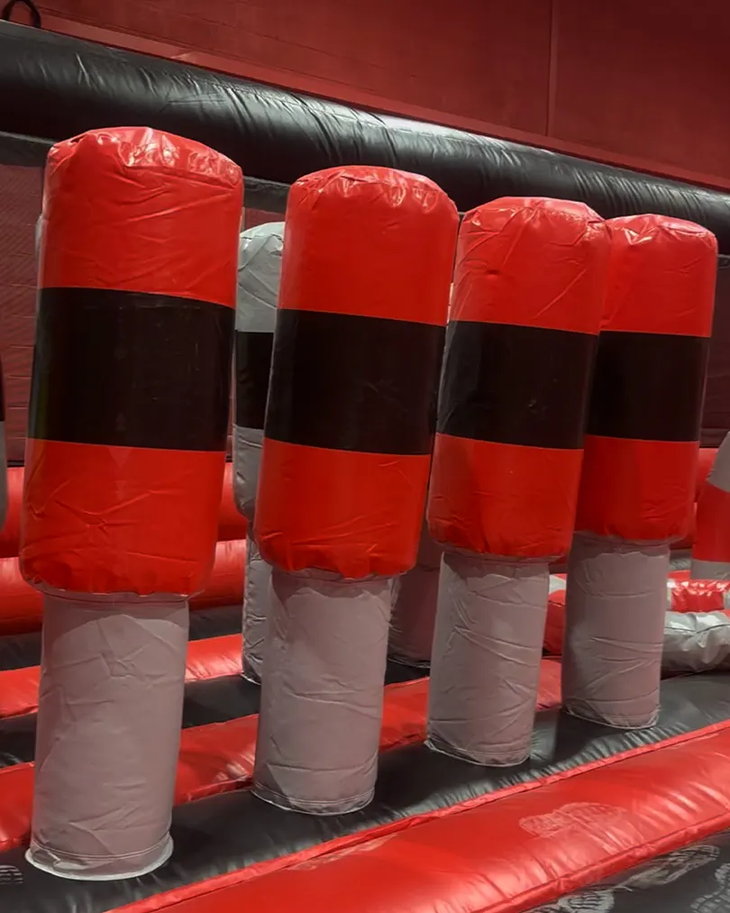 Red, black and grey inflatable obstacle course posts on a bounce house.