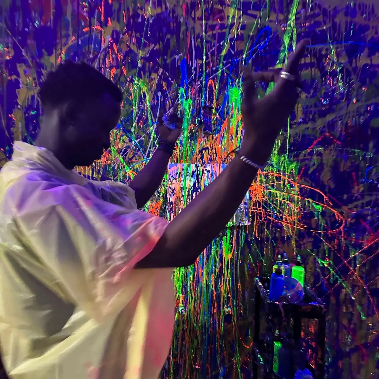 Visitor interacting with a vibrant interactive digital wall displaying colourful neon lines and patterns.