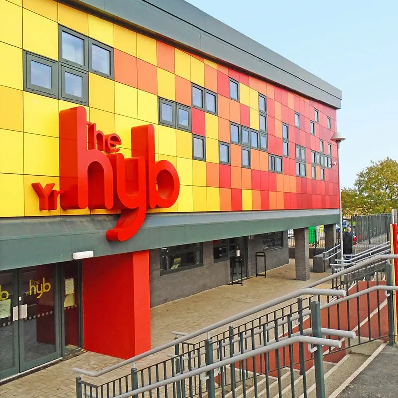 Modern leisure venue with striking yellow and red checkered facade and large red signage.