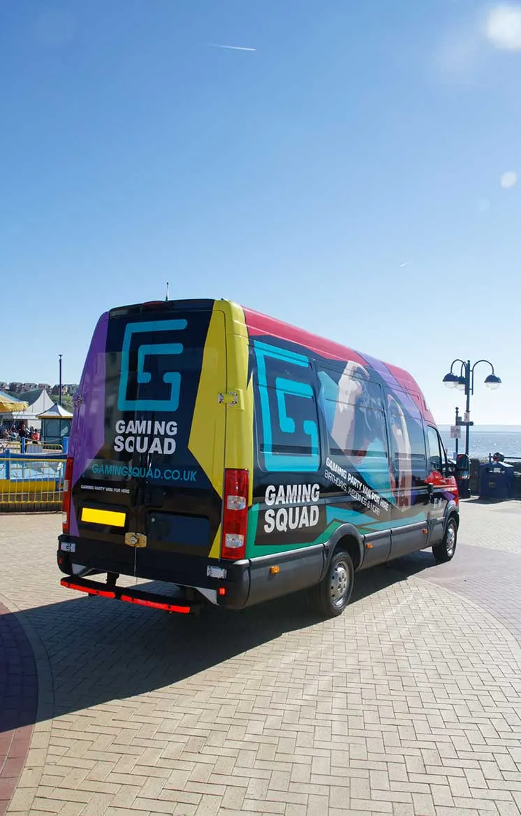 Colourful Gaming Squad branded van parked on a seafront promenade on a sunny day.