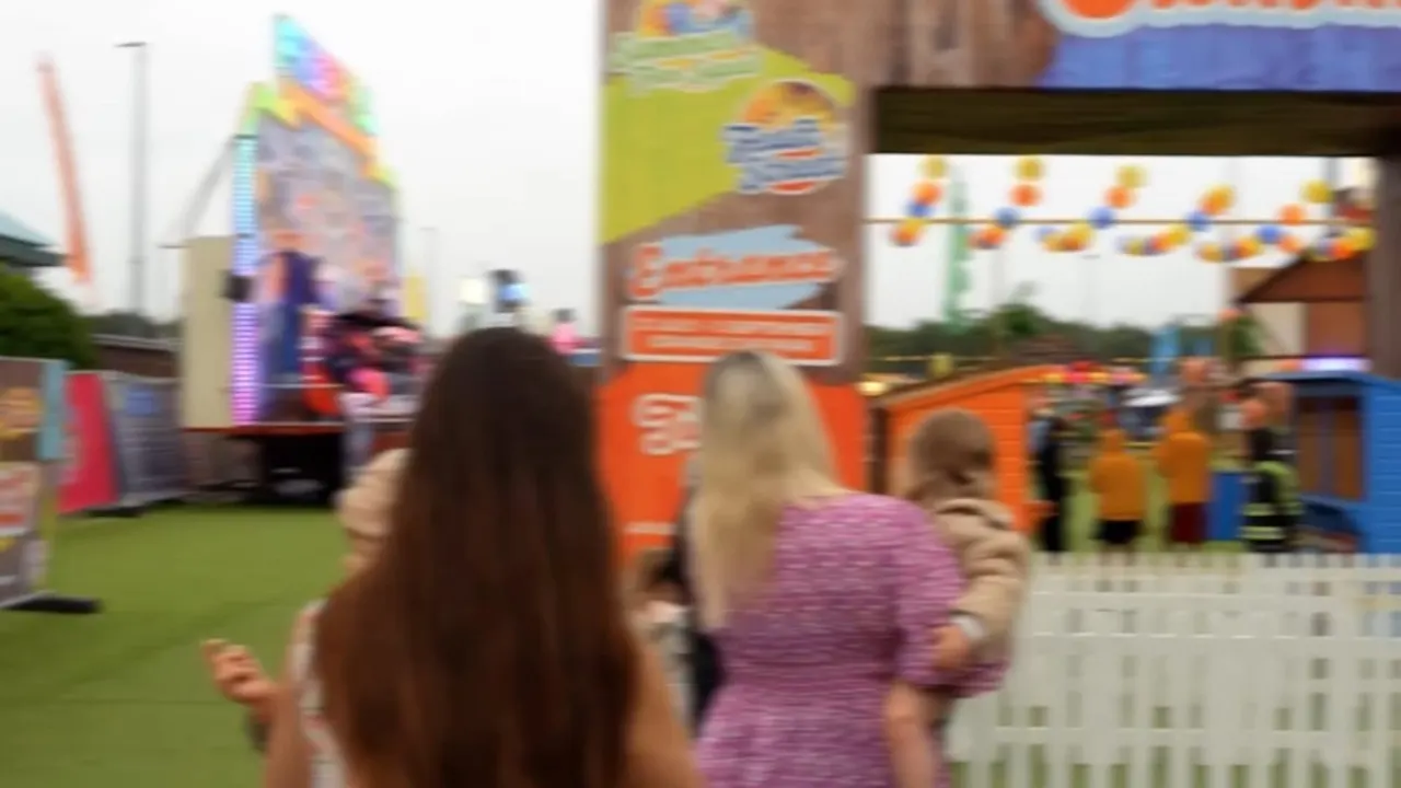 Children and adults enjoying colourful fairground attractions and rides at an outdoor summer venue.