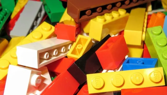 Colourful plastic building bricks in yellow, red, white, green, blue and brown scattered together.