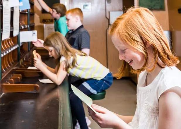 Children interact with interactive exhibits at a railway museum display.