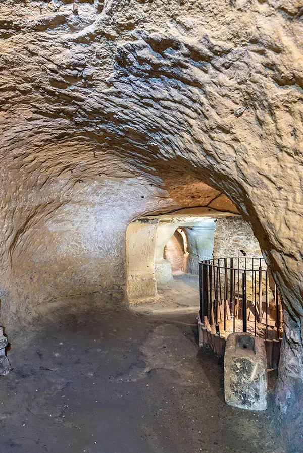 Portrait view along a lit sandstone tunnel