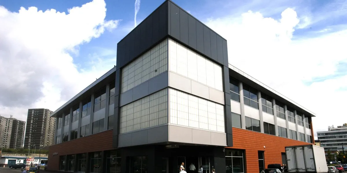 Modern multi-storey library building with black, white and orange cladding, large windows, and people entering at ground level.