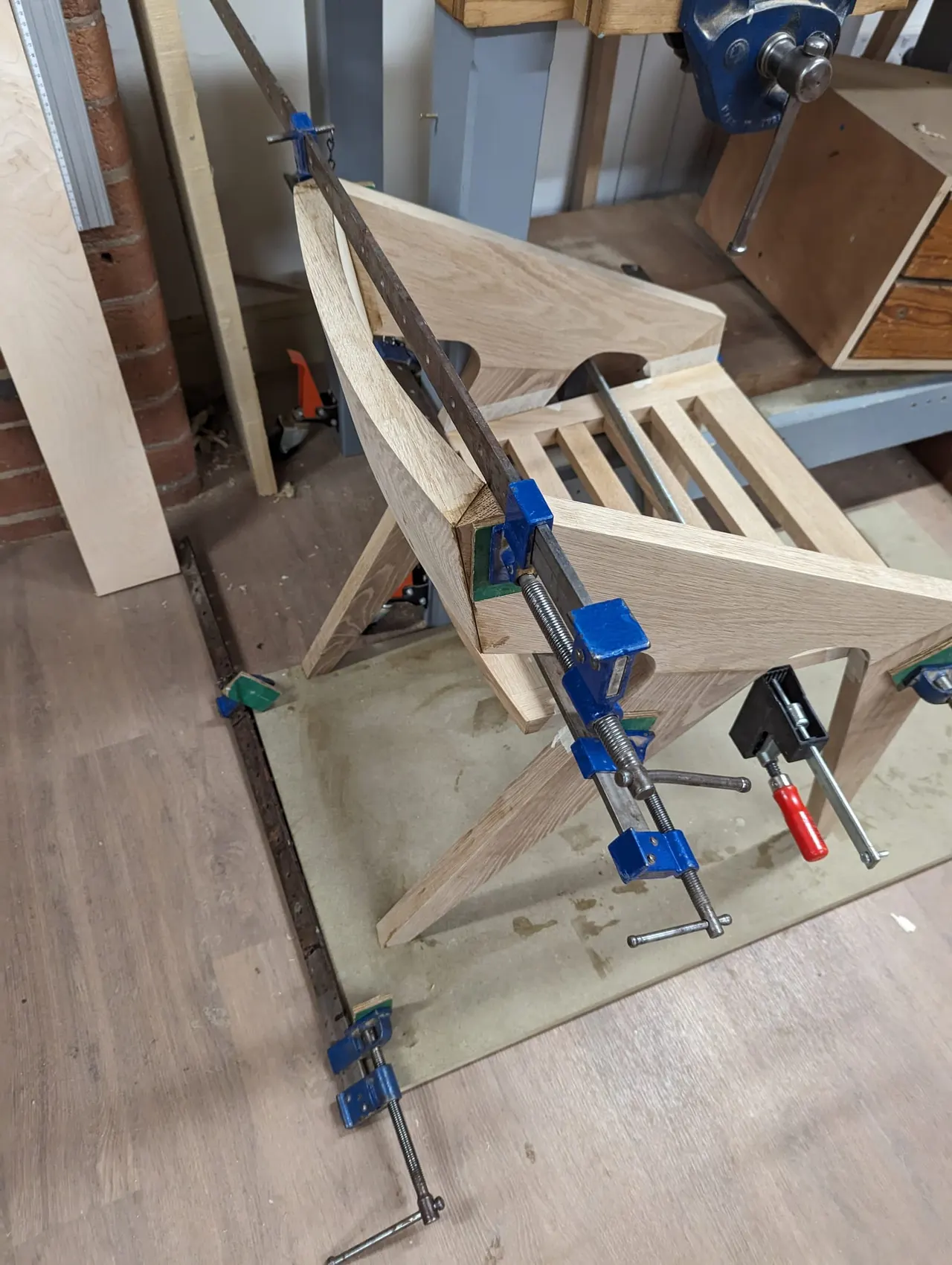 Wooden furniture frame clamped together in a workshop during construction or assembly.