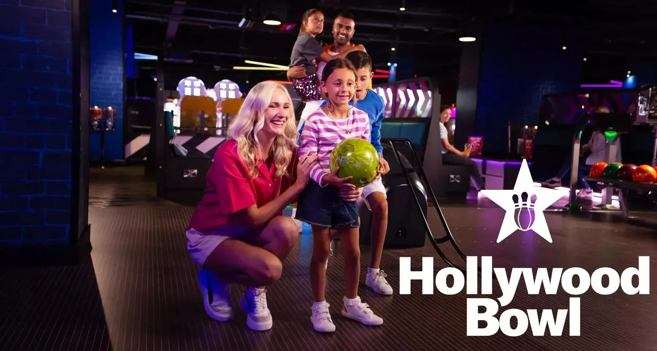 Neon purple and pink lit bowling lanes with pins and seating
