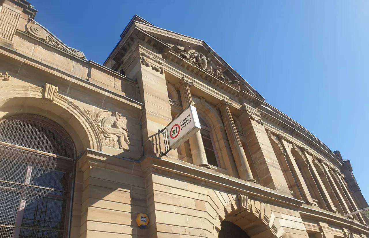 Grand Victorian stone building with ornamental architectural details under clear blue sky.