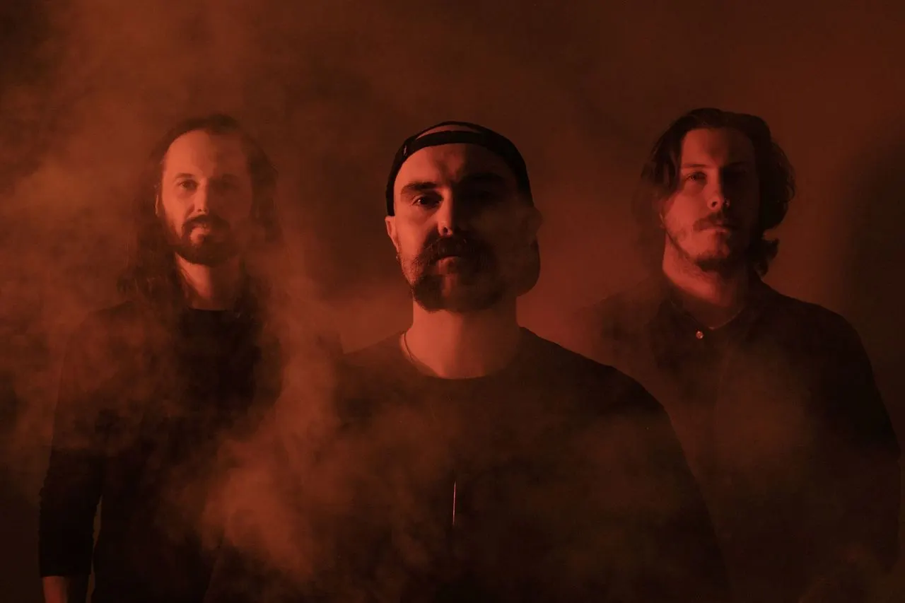 This is a designed graphic (band/artist promotional image), not a photograph of the venue itself.

GRAPHIC