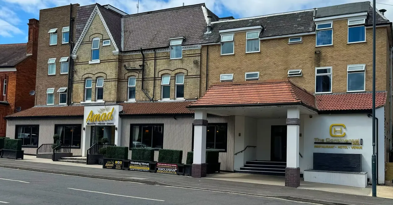 Victorian brick building with ground-floor restaurant and hotel frontages under blue sky.