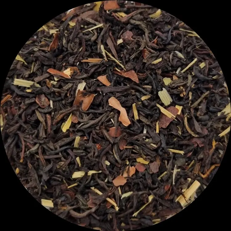 Loose leaf tea blend with dark leaves, dried fruit pieces and yellow botanicals.