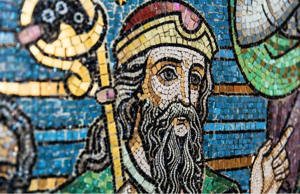 Detailed mosaic artwork depicting a bearded figure wearing a headdress and holding a staff, surrounded by colourful tiles and decorative elements.