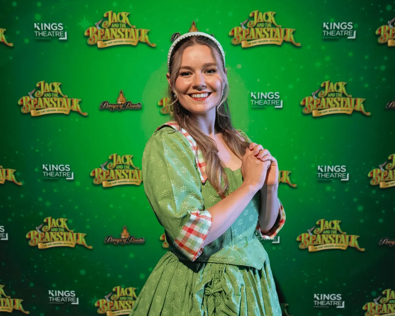 Young girl in green period costume with tiara at a Jack and the Beanstalk theatre event.