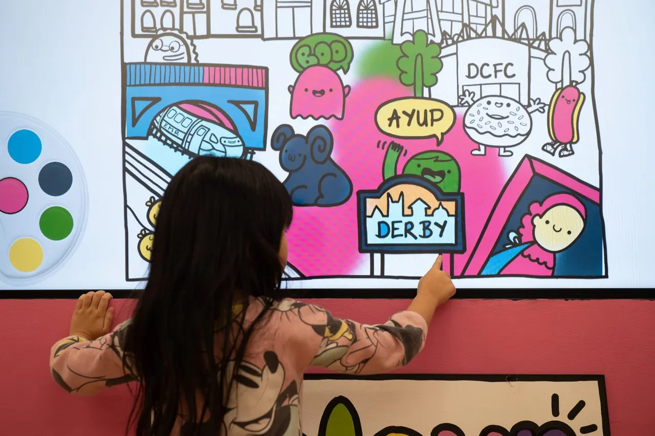 Child at interactive wall inside QUAD