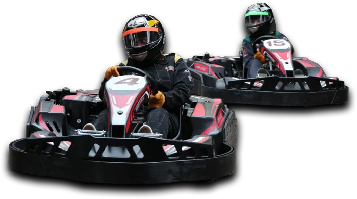 Two people in helmets racing in go-karts with red and black bodywork on an indoor track.