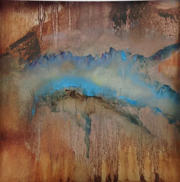 Aerial view of a geothermal hot spring with vibrant blue mineral-rich water and russet-coloured mineral deposits.