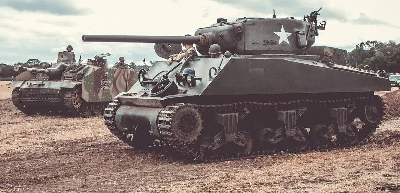 Second World War military tanks and personnel on display at an outdoor museum or heritage site.