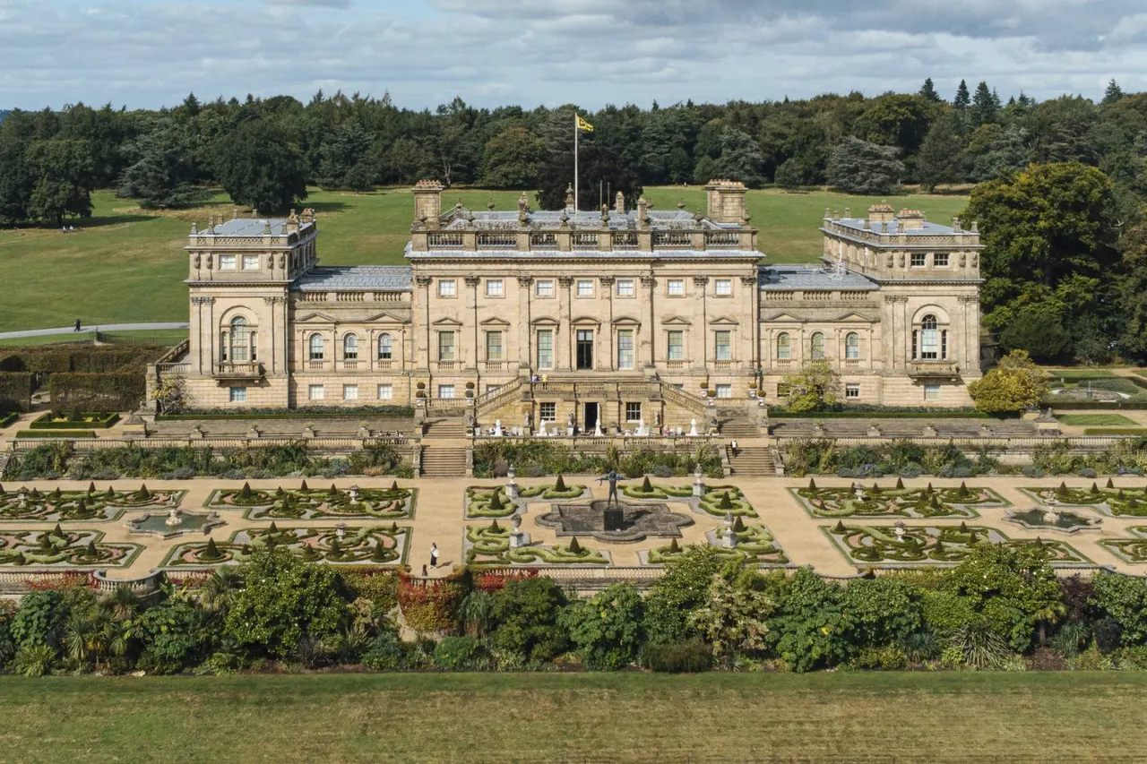 Grand stately home with formal gardens, manicured hedges and fountains, surrounded by woodland and green parkland.