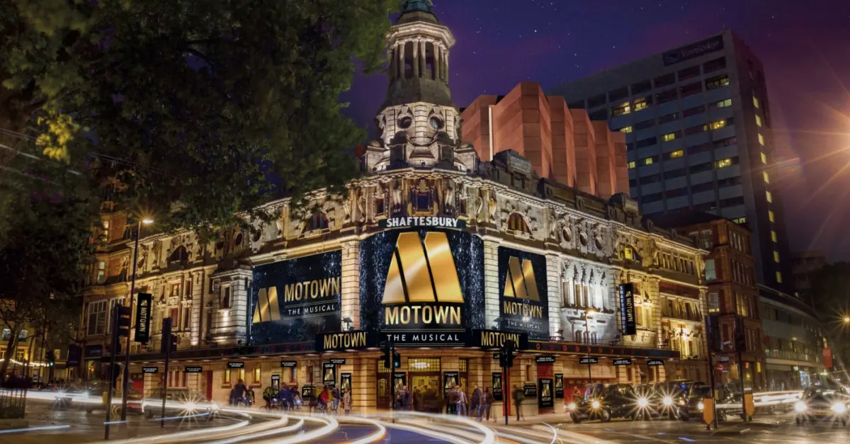 Shaftesbury Theatre illuminated at night with Motown the Musical advertising banners, surrounded by historic architecture and city streets.