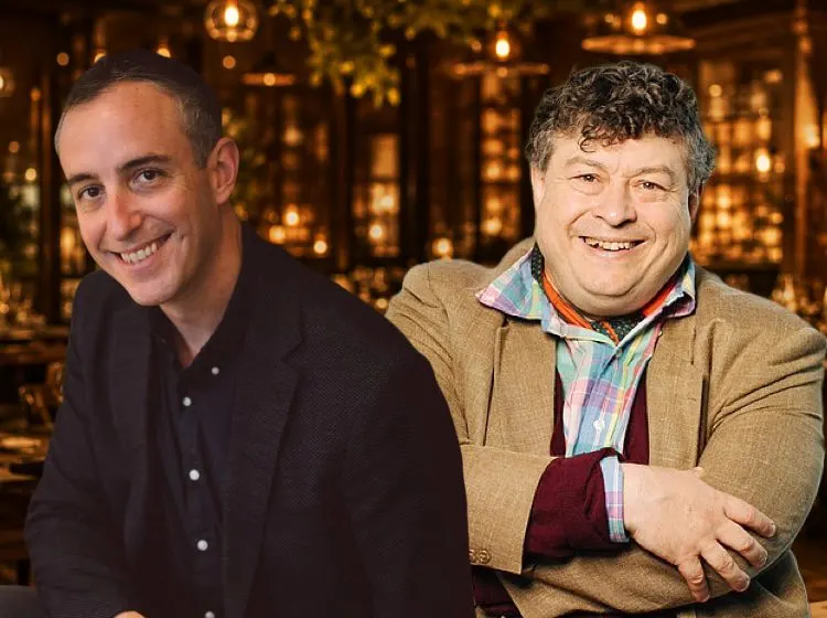 Two men smiling at the camera in an elegant venue with warm golden lighting and decorative elements in the background.