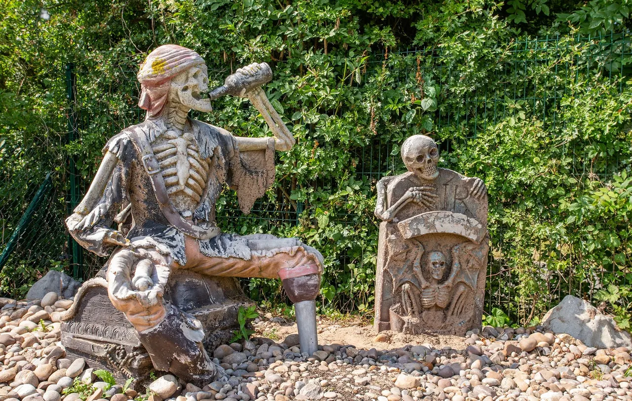 Skeletal stone sculptures depicting pirate characters among pebbles and climbing ivy.