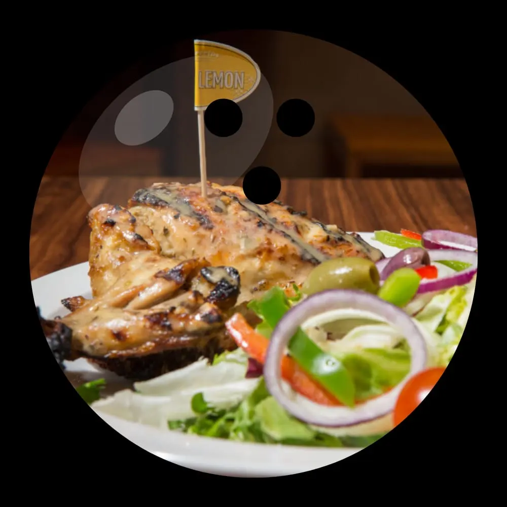 Grilled lemon chicken with fresh salad garnish and sliced onions on a white plate.