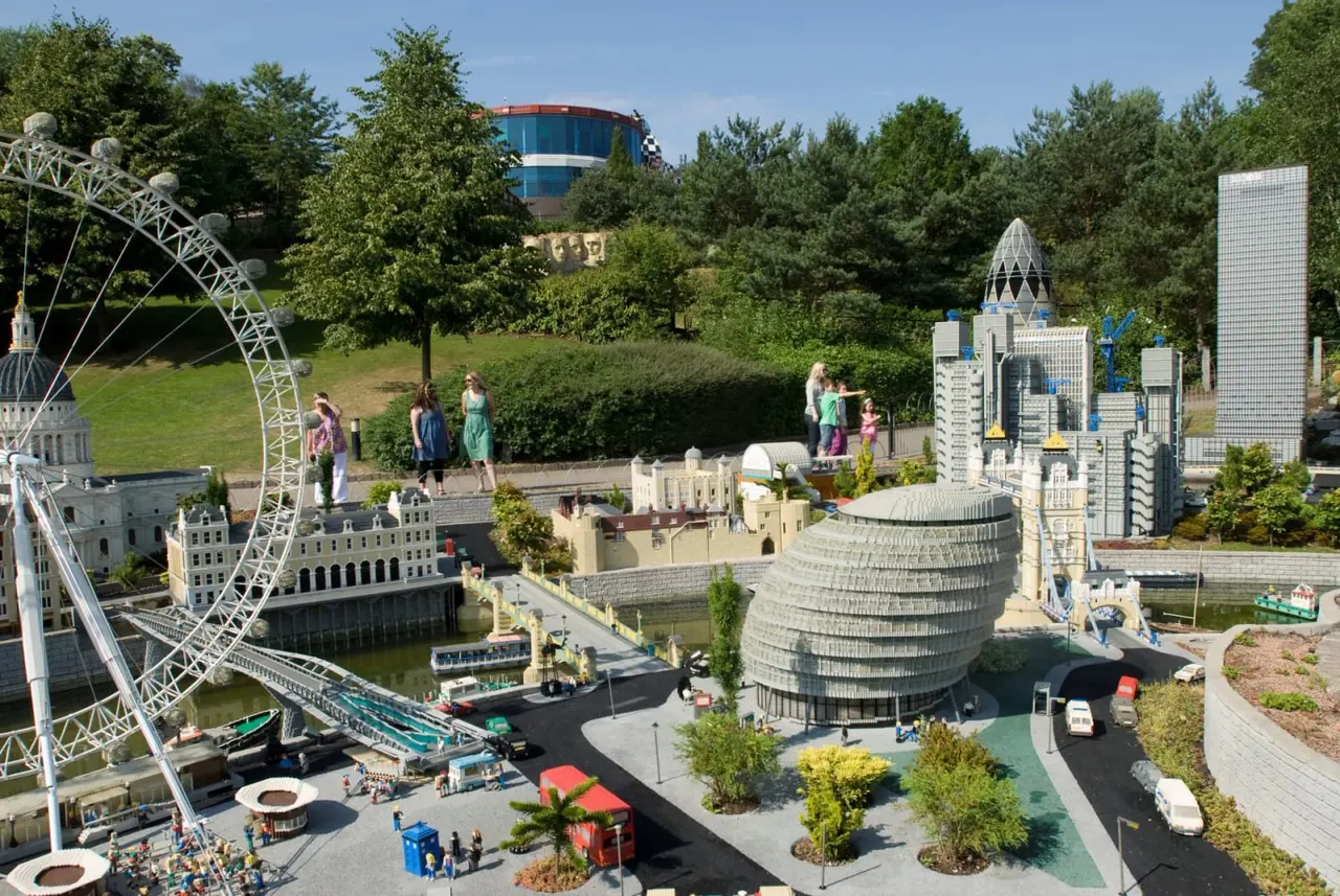 This is a PHOTOGRAPH.

Miniature model cityscape with iconic landmarks including a Ferris wheel, buildings and tower replicas, with visitors walking around the display outdoors.
