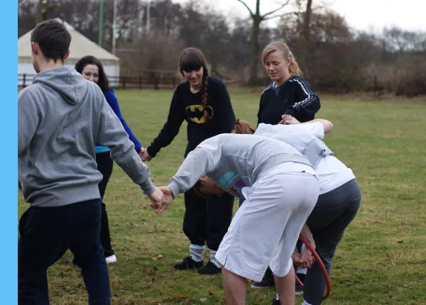A group of young people playing touch rugby or a similar team sport on a grass field.