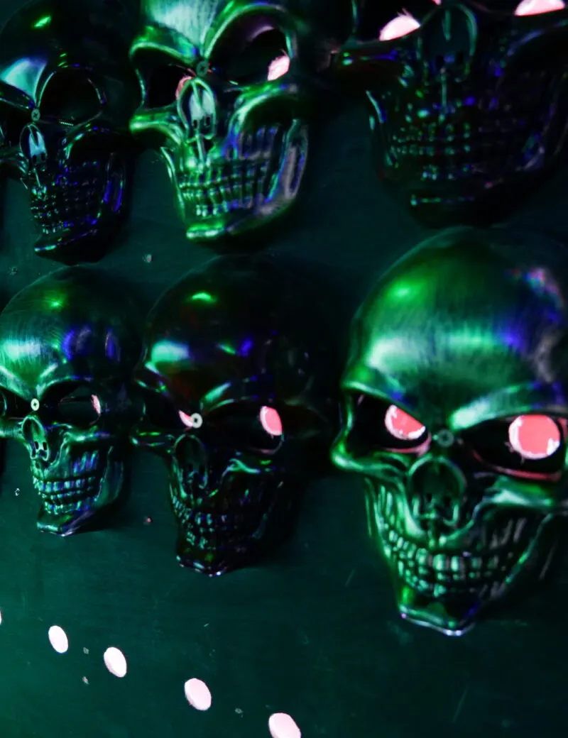 Illuminated skull decorations with glowing green and pink neon lighting in a dark venue setting.