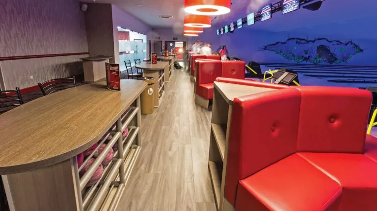 Red lane seating, ball racks and purple-lit bowling lanes inside Mansfield Superbowl