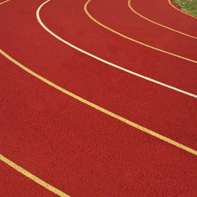 Red running track with white and yellow lane markings.
