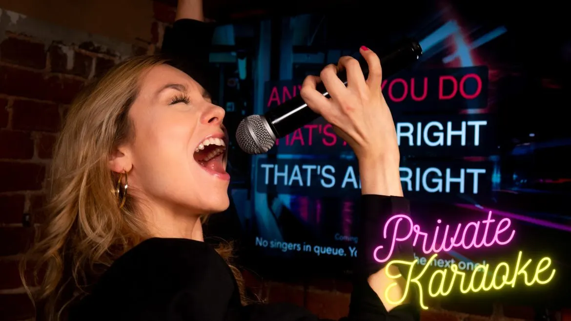 Woman singing into a microphone at a private karaoke venue with neon signage in the background.