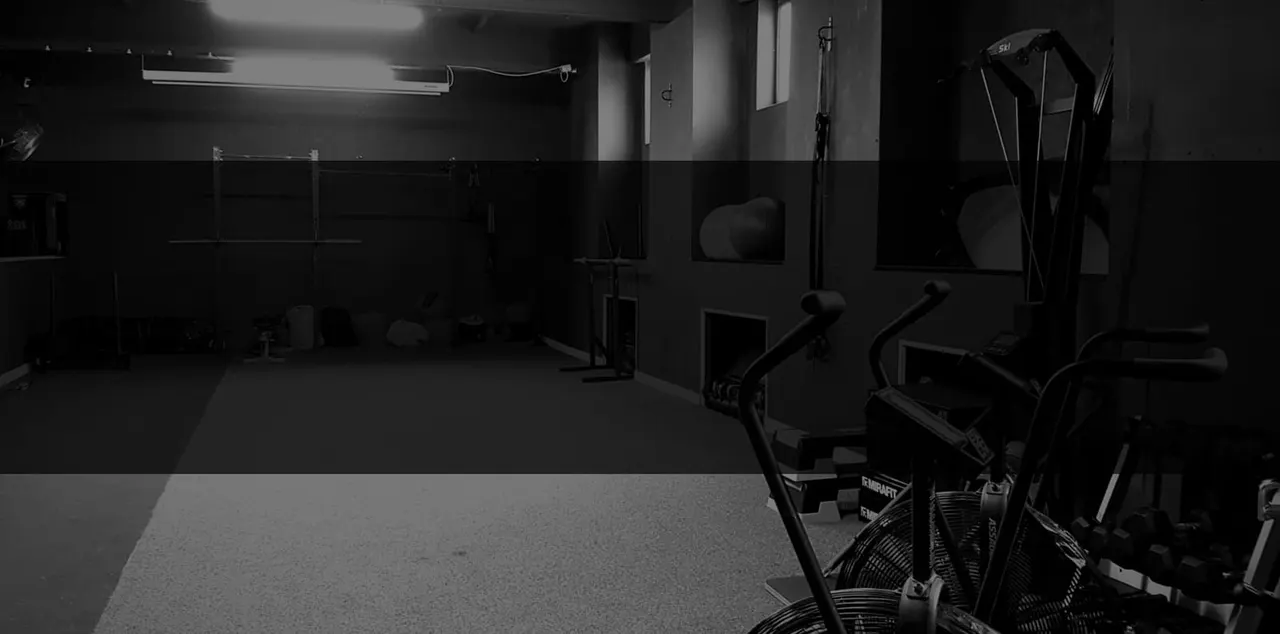Exercise bikes and gym equipment in a modern fitness studio with mirrored walls.