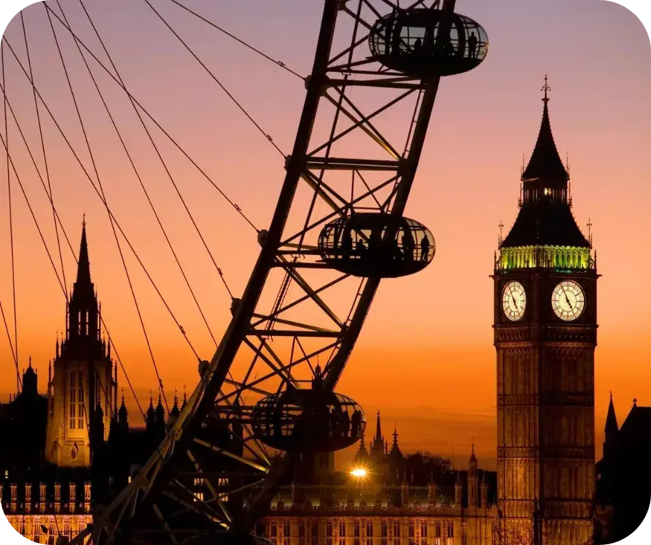 A giant observation wheel silhouetted against an orange sunset sky, with Big Ben and Houses of Parliament illuminated in the background.