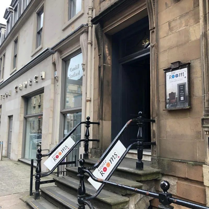 Stone-built historic building entrance with a dark doorway numbered 35, flanked by branded railings for the venue.