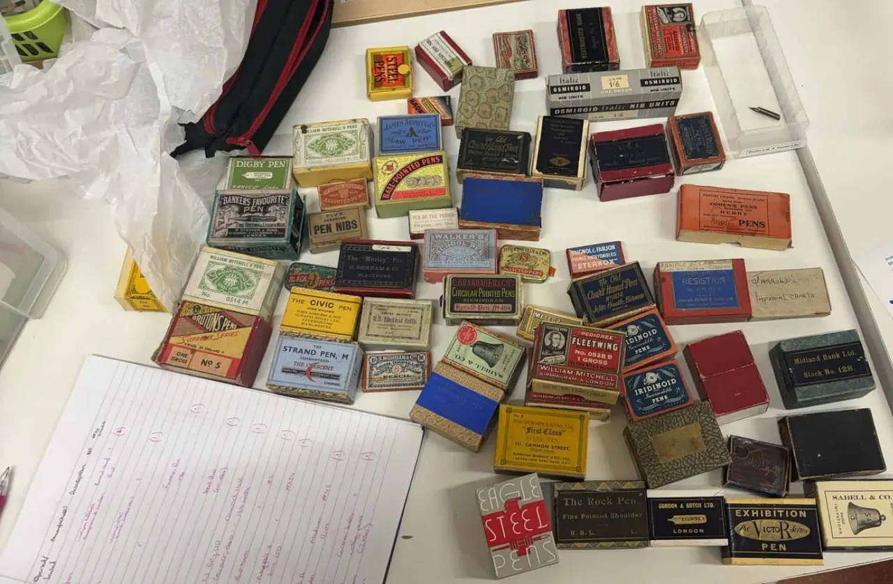 Extensive collection of vintage pen boxes and packaging from various manufacturers arranged on a white surface next to handwritten notes.
