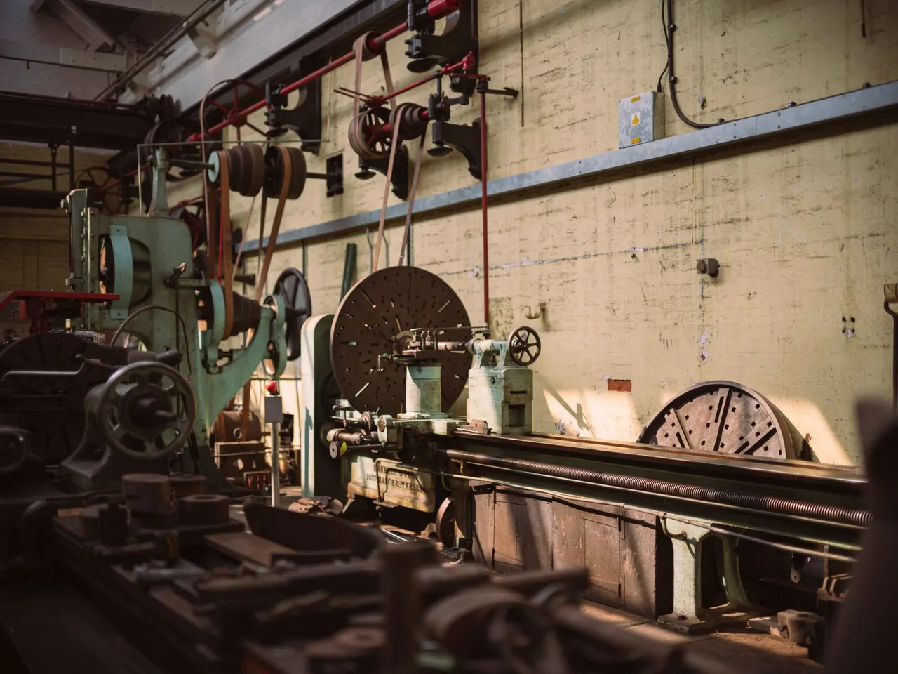 Industrial heritage workshop interior with vintage lathe machinery and metal fabrication equipment.