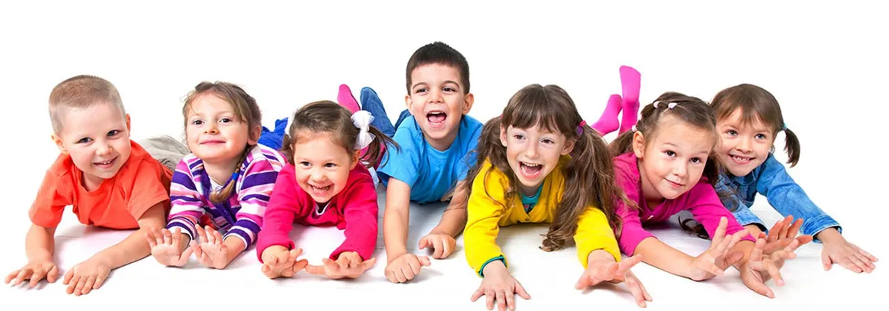 A group of eight young children in colourful clothing crawling and playing together on a white background.