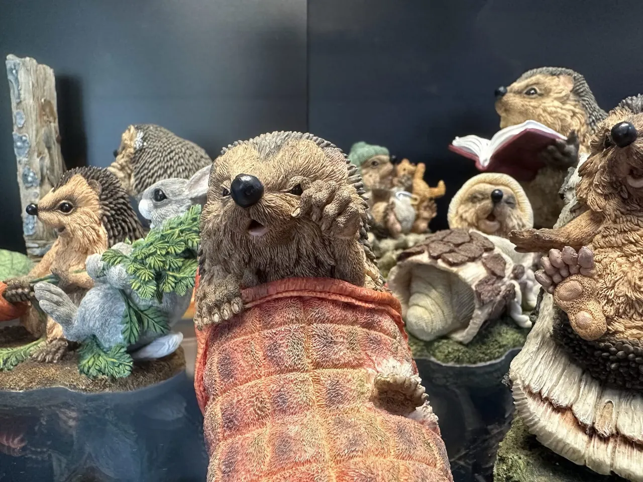 Collection of decorative figurines depicting small mammals in natural poses against a dark background.