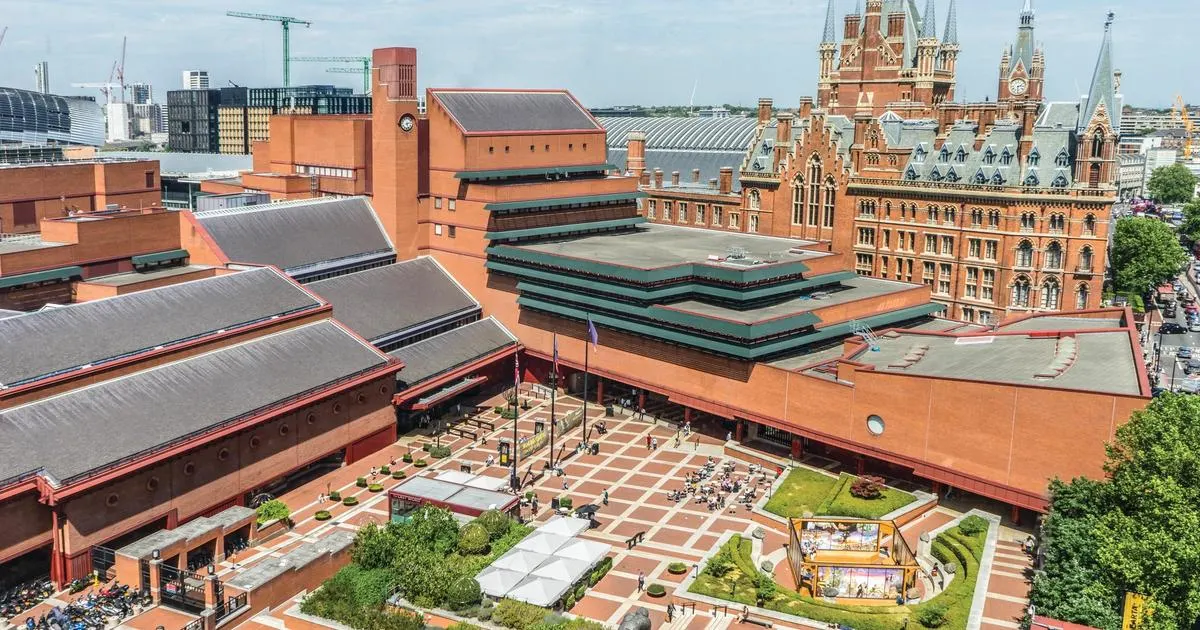 Aerial view of a red-brick cultural building complex with courtyards, visitors, and surrounding London architecture including a Gothic tower.