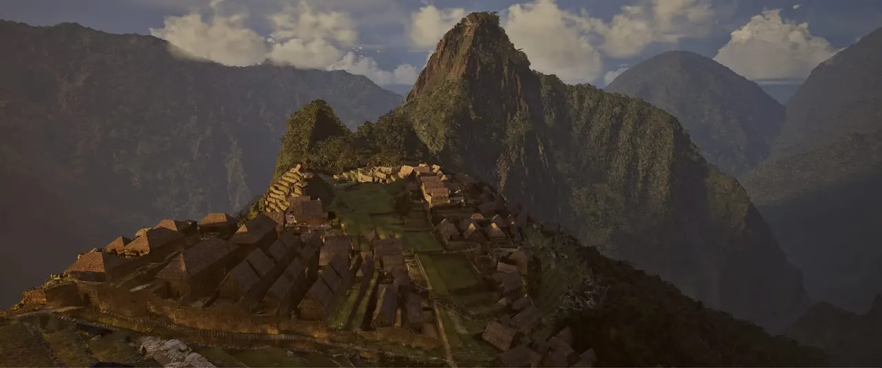 Ancient stone ruins sprawl across a mountain peak surrounded by dramatic forested peaks under a cloudy sky.