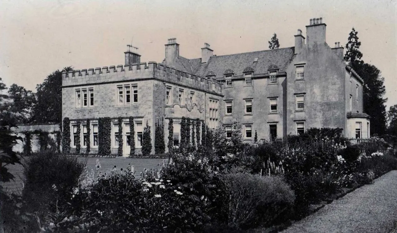 A substantial stone mansion with castellated walls and multiple chimneys, surrounded by manicured gardens and topiary.