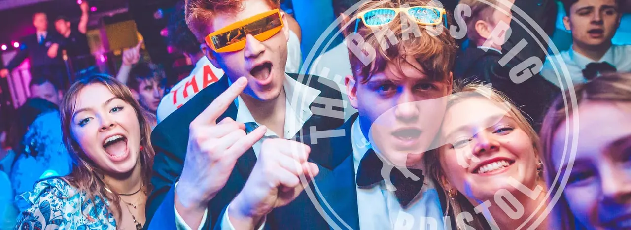Young people wearing novelty sunglasses dancing and celebrating in a colourful nightclub with purple and blue lighting.
