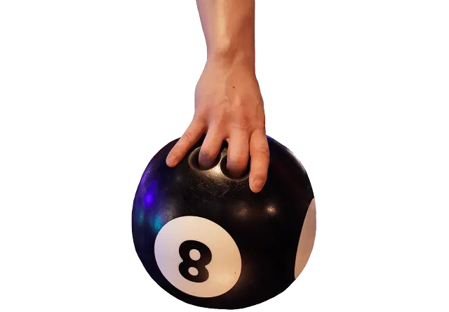 A hand gripping a black bowling ball with a white number 8 on it.