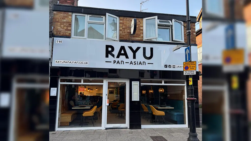 Front exterior of Rayu Pan-Asian restaurant showing storefront with large windows and yellow seating visible inside.
